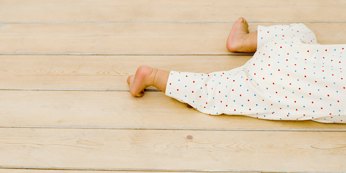 Bambino che gioca sul pavimento pulito a casa.